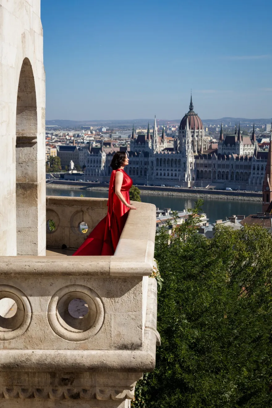 Ingrid im roten Kleid auf der Fischerbastei in Budapest mit Blick aufs Parlament