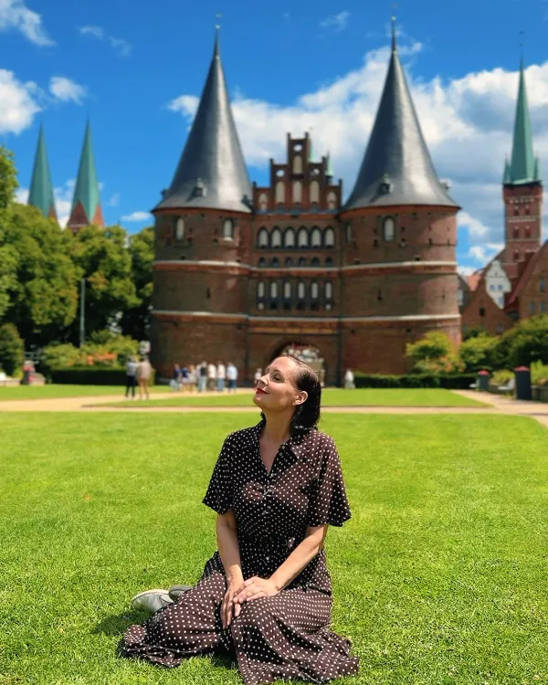 Ingrid im gepunkteten Kleid auf der Wiese vor dem Holstentor in Lübeck